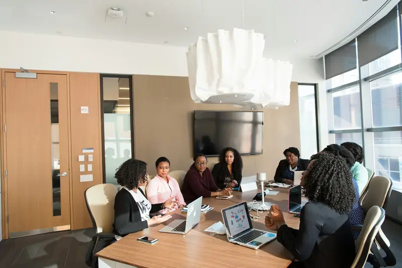 A team meeting around a long table in a bright office