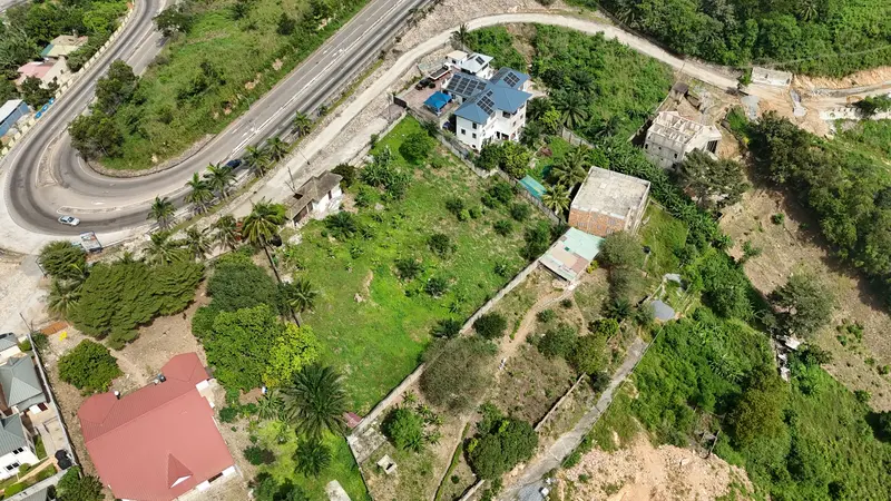 Aerial view of a green hillside with houses and roads